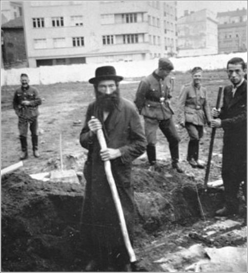 German soldiers amuse themselves while they force Jews to dig ditches in an empty lot in Krakow